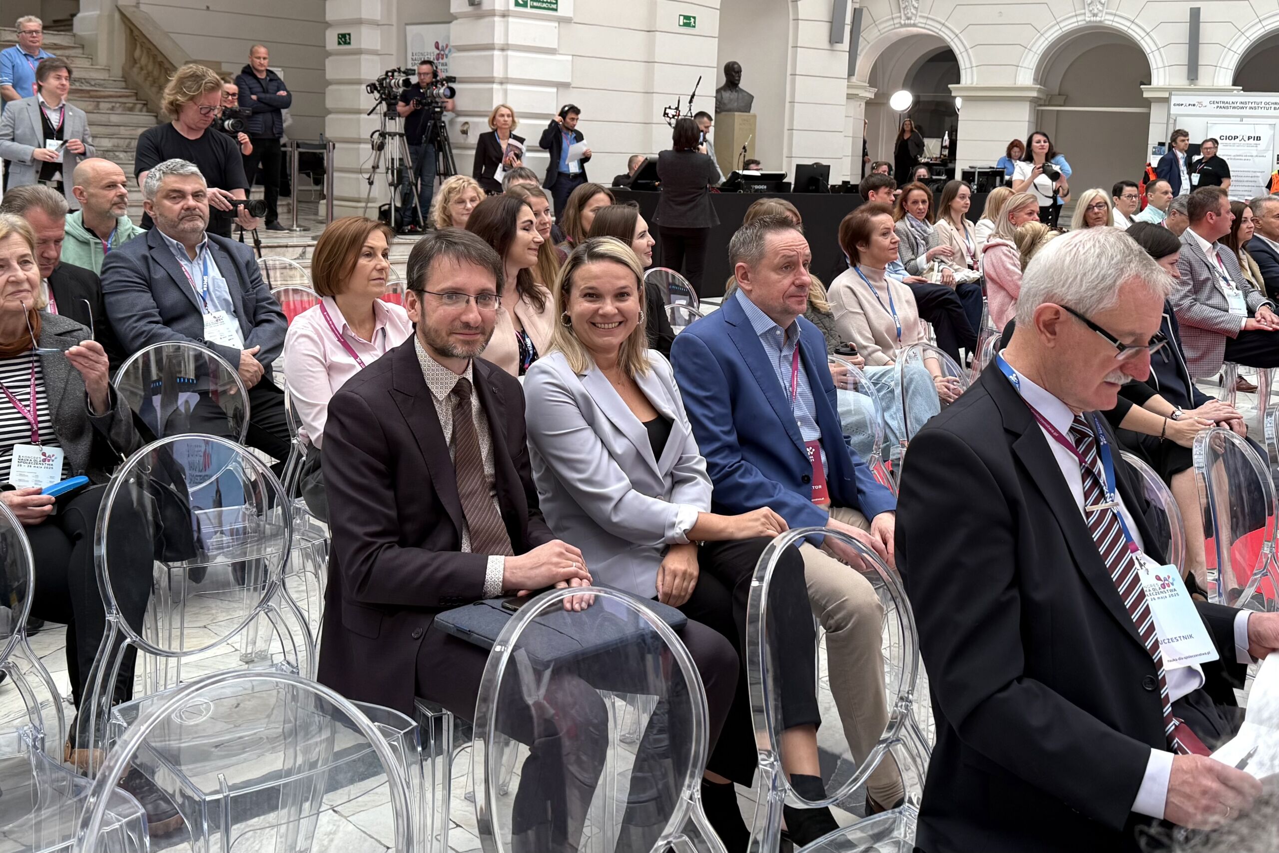 Uczestnicy kongresu siedzą na patio Politechniki Warszawskiej.