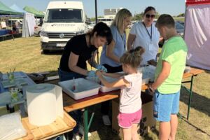 Dzieci przy stoisku edukacyjnym robią doświadczenia