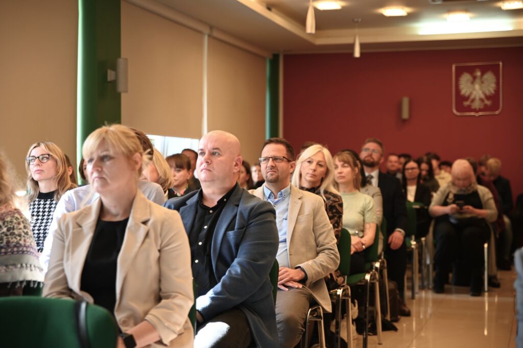 Uczestnicy konferencji siedzą na sali.