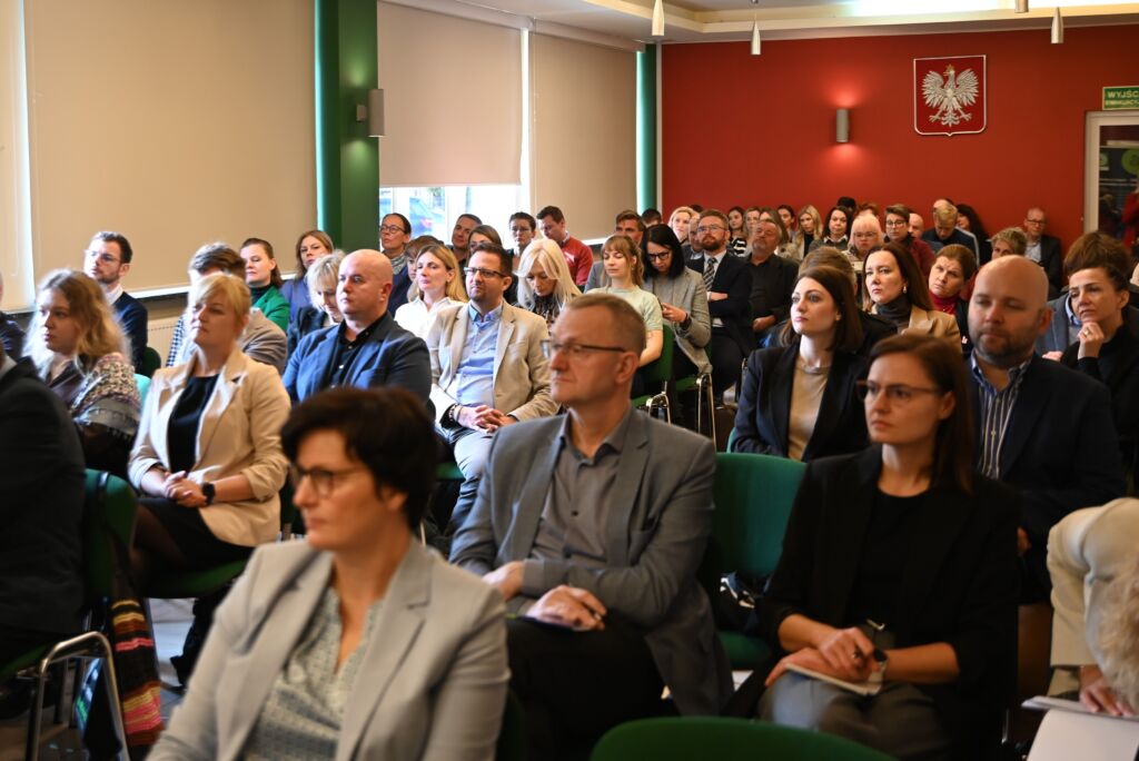 Uczestnicy konferencji siedzą na sali.
