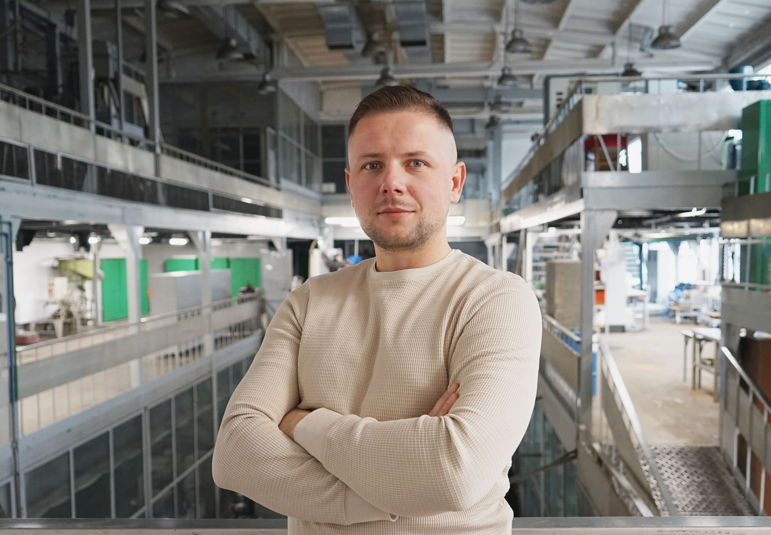Domnik Borkowski na tle hali technicznej w Łódzkim Instytucie Technologicznym