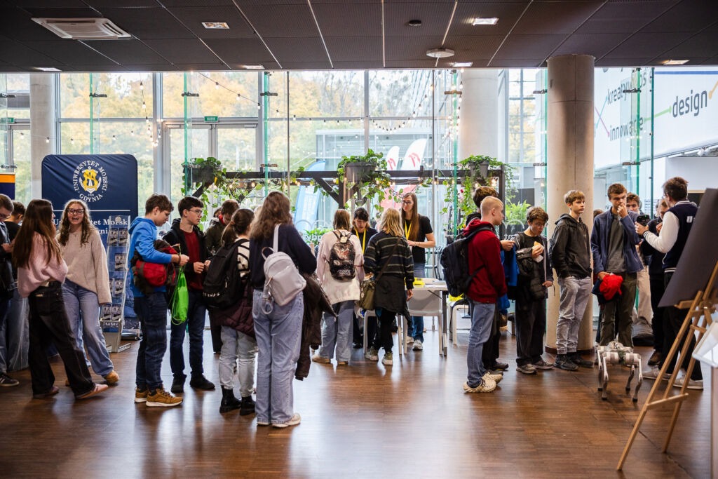 Młodzież przy stoliku Łukasiewicz - Łódzkiego Instytutu Technologicznego ogląda eksponaty