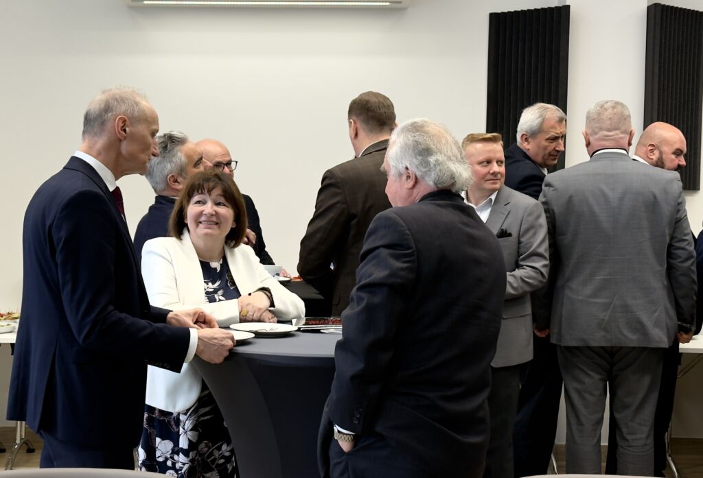 Uczestnicy konferencji rozmawiają przy stoliku.