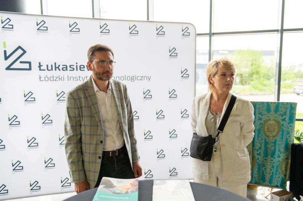 Pracownicy instytutu badawczego na stoisku wystawienniczym.